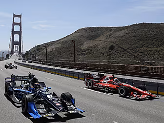 IndyCars travel over the Golde...