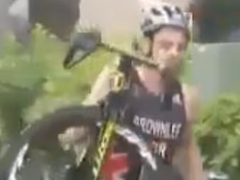 Triathlete carries bike for on...