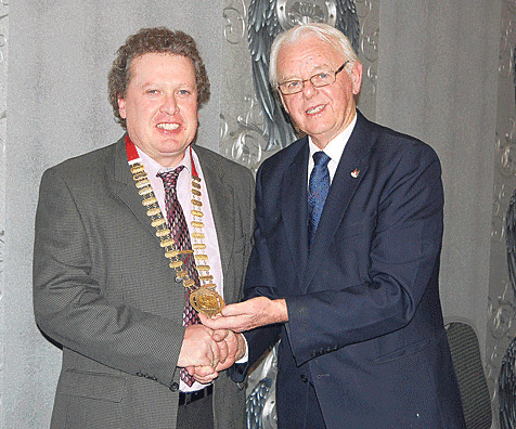 Changing of the guard: Paddy Buckley (right), outgoing chairman of the Cork County Board of Athletics Ireland, presented the chain of office to newly-elected chairman Bill 