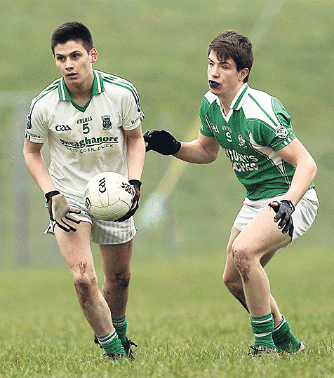 Looking ahead: Ilen Rovers Daniel ODriscoll breaks out of defence with the ball, as Dohenys Jamie Carroll closes in, during the U21 A quarter-final at Aughaville on Sunday.