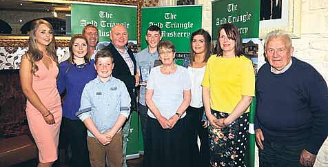 A proud moment: Sean ODonoghue, Inniscarra GAA, photographed with family members as he receives the Muskerry GAA/Auld Triangle Sports Award for March from Michael ORiordan at the awards function.   