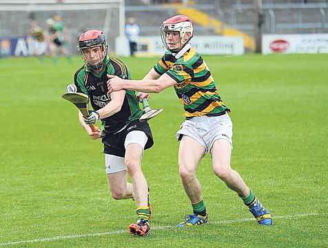 Darren McCarthy of Ballymartle, in possession, keeps his eye on the ball as Dave Noonan, Glen Rovers, at Pairc Ui Rinn during their sides senior hurling championship first round clash on Saturday last.
