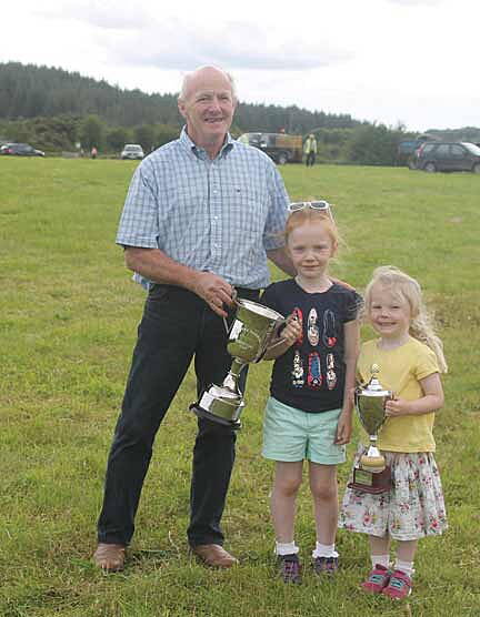 A family affair: Pete Hill, owner of Hail Spartacus, winner of the Thomas Harrington Cup, is pictured with his granddaughters Aoibhe and Sarah Kate Cremin, with the Driver of the Day Cup won by their uncle, Patrick Hill, at Gloun.