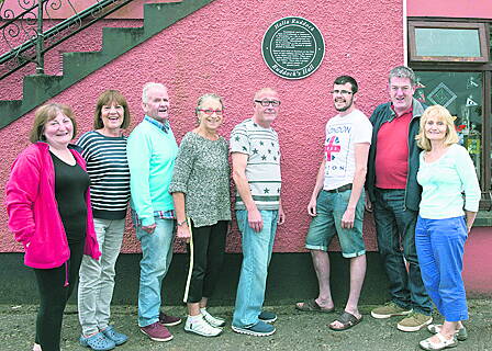 Members of the Courtmacsherry Tidy Towns Committee beneath the plaque at Ruddock