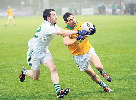 Jerry McCarthy of Dohenys, in possession, is challenged by Aghadas Colm Power in the first round of the County Senior Football Championship.