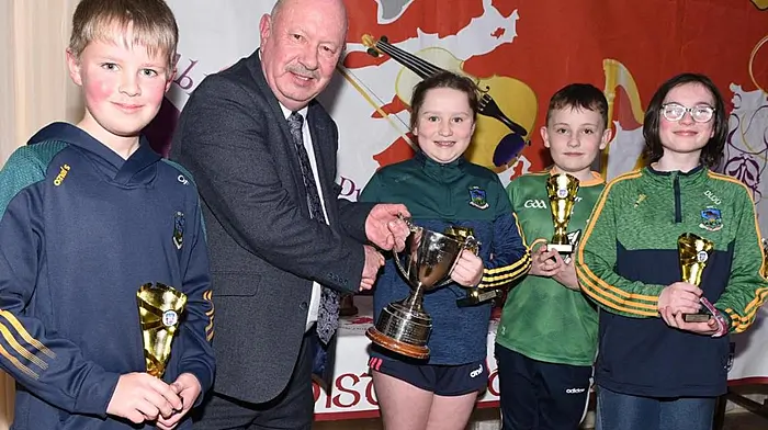 The Kilmacabea Scór na bPáistí Tráth na gCéist team of Oran French, Siobhán O’Donovan, Tadhg O’Donovan and Áine Ní Lochlainn being awarded Corn Dú Eala from Donal MacSuibhne, cultural officer of Cork GAA county board for winning the county final last Saturday in Ovens.