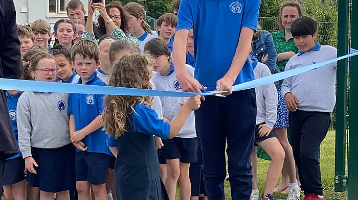Indie McCarthy and Benjamin Graves cutting the ribbon to unveil the state-of-the-art sports facility at Dunderrow National School.