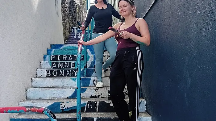 Helen O'Keeffe and Shena Yolzari repainting the mural of Anne Bonny in Kinsale.