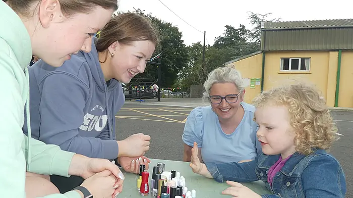 Nail artists Abbie and Amy Sheehan with Noelle Carey and little Grace Carey, carefully choosing her favourite colour – yellow - for her nails at the Gaggin summer barbecue.