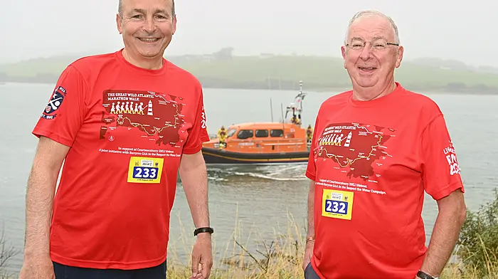 An Tánaiste, Minister for Foreign Affairs and Minister for Defence Micheál Martin (left) with Ray Doherty, Courtmacsherry, at the beginning of the Great Wild Atlantic Marathon Walk which was held recently.  The event is a major fundraiser for the Courtmacsherry RNLI station, one of the oldest lifeboat stations in Ireland.  The RNLB Val Adnams, the Shannon-class lifeboat, is in the background.  (Photo: Martin Walsh)