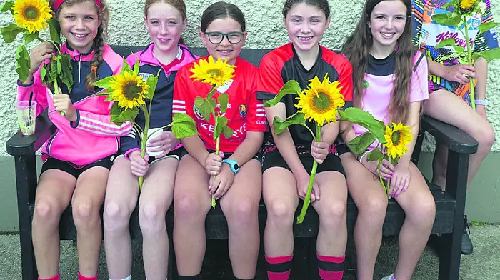 Éabha O’Leary, Grace O’Sullivan, Kate O’Flynn, Odette O’Donovan Forcey, Éala Pattwell
and Sadhbh O’Flynn saying it with flowers at Dineen’s field in Ballinascarthy.