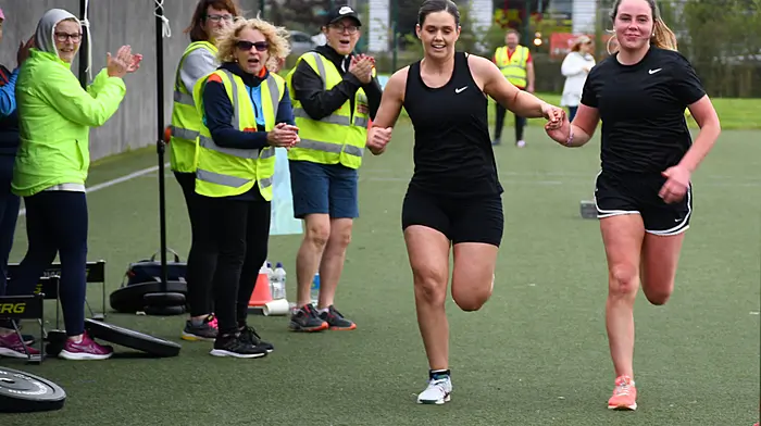 Orla O'Regan and Niamh McCarthy sprinting across the finish iine after competing in the Hyrox Endurance Event in Skibbereen. (Photo: Garry Minihane)
