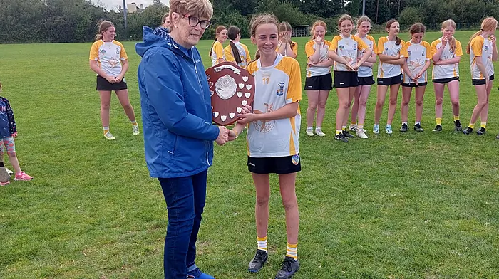 Aoife Fleming, captain of the Bandon U13 team, receiving the plate from Marie O’Donovan, sister of the late Kathleen O’Leary, in whose memory the Kathleen O’Leary memorial blitz was recently held at the Charlie Hurley park in Bandon.