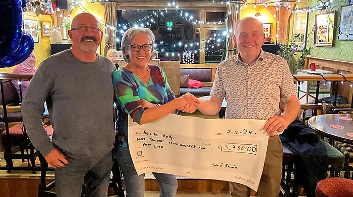Deirdre Kelly, along with John Kelly, being presented with a cheque for €3,750 from GAA chairman Sean Dineen after she recently won the lotto jackpot.