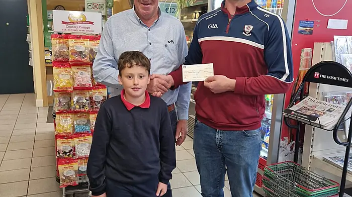 Fionn Doonan (junior captain of Muintir Bháire GAA) presenting Mackey O’Mahony (left) from Ballydehob with a cheque for €7,000 after he won the jackpot in the Muintir Bháire lotto. The presentation took place at The Village Grocer in Durrus where Mackey bought the winning ticket. Also included is Mackey's grandson Matthew O'Mahony, who plays with the Muintir Bháire U10 team.