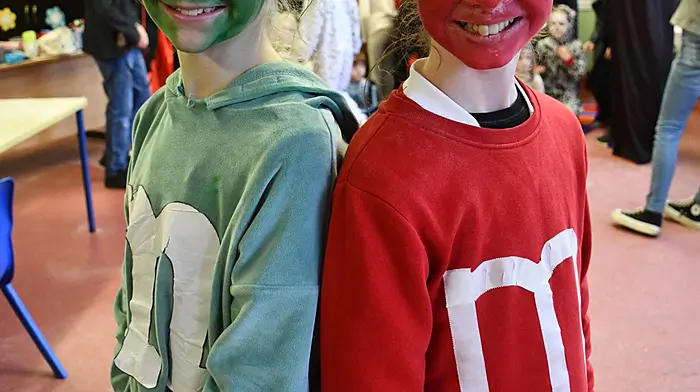 Dressed as M&Ms were Emma McCarthy and Kate Lynch for the Dreeny National School Halloween party. Right: Firemen Keith Faithfull and Aidan Whelton from Bandon Fire Service putting up their scarecrow in Leap for the festival. (Photos: Anne Minihane & Andrew Harris)