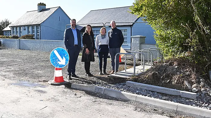 Christopher O’Sullivan TD, Catherine Foley (school principal), Betty Kenneally (board of management) and Sean Keohane (parents association) on the new footpath which is currently being constructed.  (Photo: Martin Walsh)