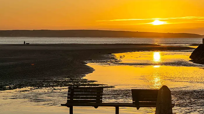 Two people walking their dogs as the sun rises over Rosscarbery’s old pier as a prelude to a day of autumn sunshine. (Photo: Andy Gibson)