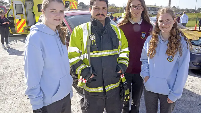 NEWS 2/4/2025 Pictured at a RTC Road traffic simulation for the transition year students of Bandon secondary schools involving the Ambulance service Fire Service and Garda at Bandon GAA were St Brogans college students Katie Jean Cronin, Hallam Tenyson and Kate Westcott with firefighter Bruno R' Silva. Picture Denis Boyle