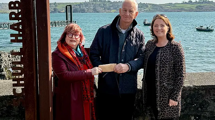 Simon Nelson of Schull Water Sports Centre presenting Maura Allen of Schull Tidy Towns a cheque for €1,060, along with Cllr Caroline Cronin.