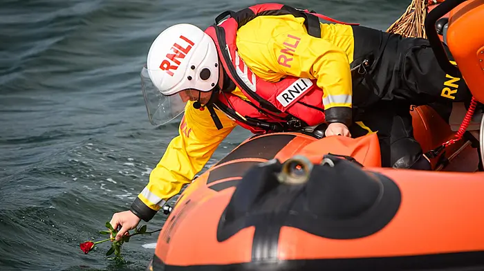 A Kinsale RNLI crew member places a flower in the harbour  to mark seafarers who have died, during the recent annual Sea Sunday remembrance in Kinsale.Picture. John Allen
