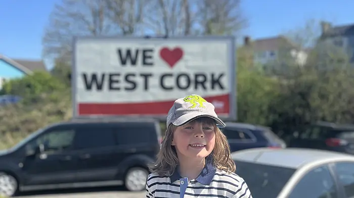 Enjoying the fine weather in front of the Southern Star billboard in Bantry is Roan Dufétel (6) from Bere Island.