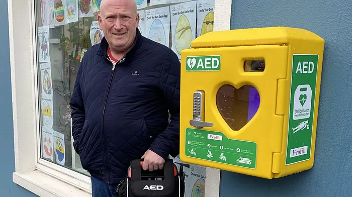 Barry Hennessy of Hennessy Transport Ltd placing the defibrillator into the AED unit at Drinagh Pharmacy, Ballineen.