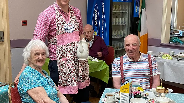 Michael and Frances O’Halloran, and with Jim Cooney behind Aindrias Moynihan, all enjoying a cup of tea at the annual tea day in Macroom which was held in aid of the Alzheimer’s Society of Ireland.