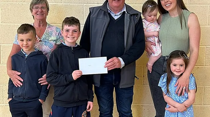 Bus driver Tom Collins recently retired after driving the school bus for ten years. From left: Leo Collins, his grandson, Kay Collins, Jack O'Callaghan presenting a voucher to Tom, Claire Collins and daughters Grace and Hannah Mae at Bishop Galvin National School.