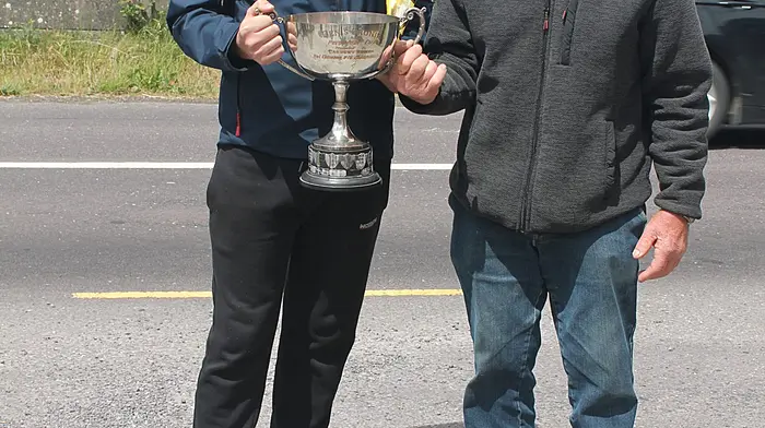 The Carbery U16 road bowling champion for 2025, Eoin Crowley from Dreenatra in Schull, receiving the winning cup from referee Diarmuid Herlihy.