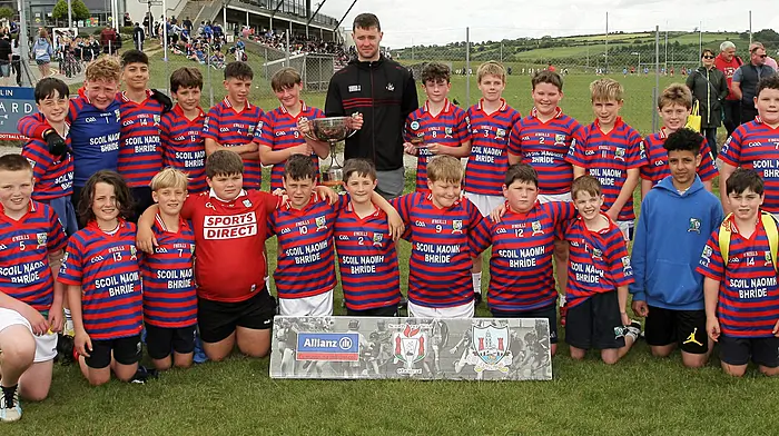 Roinn 4 Boys winners Union Hall NS receive the trophy from Cork footballer Maurice Shanley.
