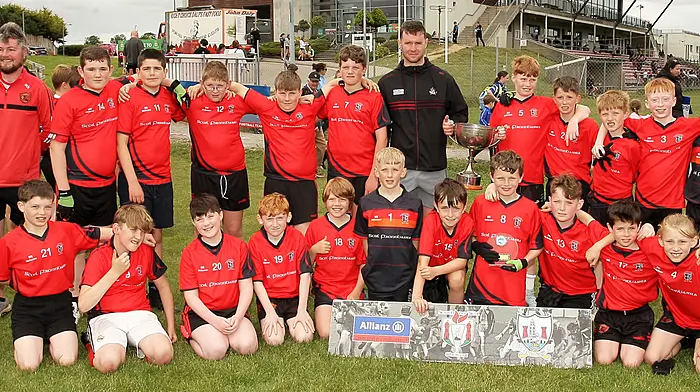 Roinn 5 Boys winners Scoil Fhionnbarra, Béal Átha’n Ghaorthaidh receive the trophy from Cork footballer Maurice Shanley. (Photo: Paddy Feen)