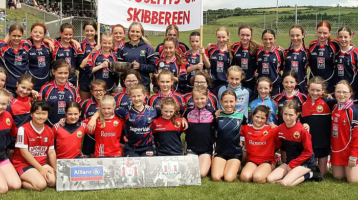 Roinn 1 Girls winners St Josephs Skibbereen receive the trophy from Cork footballer Laura O'Mahony.(Photos: Paddy Feen)