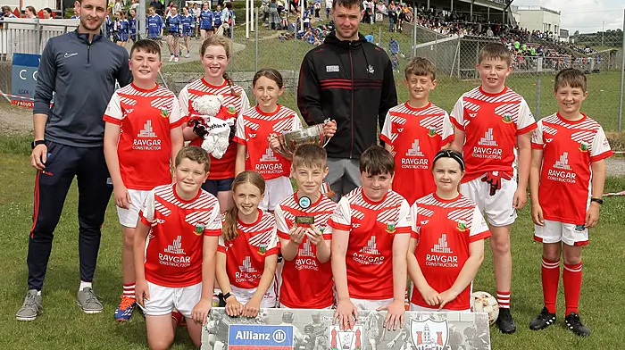 Roinn 10 Mixed winners Urhan NS receive the trophy from Cork footballer Maurice Shanley. (Photo: Paddy Feen)