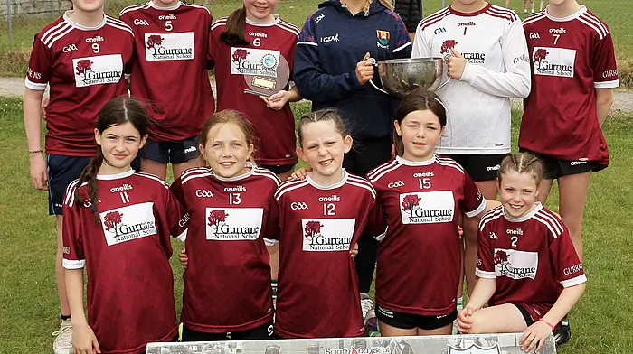 Roinn 6 Girls winners Gurrane NS receive the trophy from Cork footballer Laura O'Mahony.