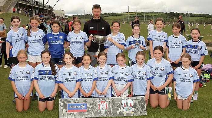 Roinn 4 Girls winners Scoil Mhuire NS Schull receive the trophy from Cork footballer Maurice Shanley. (Photo: Paddy Feen)