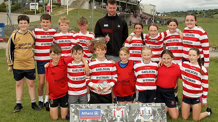 Roinn 7 Mixed winners Gaelscoil Dr Uí Shúilleabháin, Skibbereen receive the trophy from Cork footballer Maurice Shanley. (Photo: Paddy Feen)