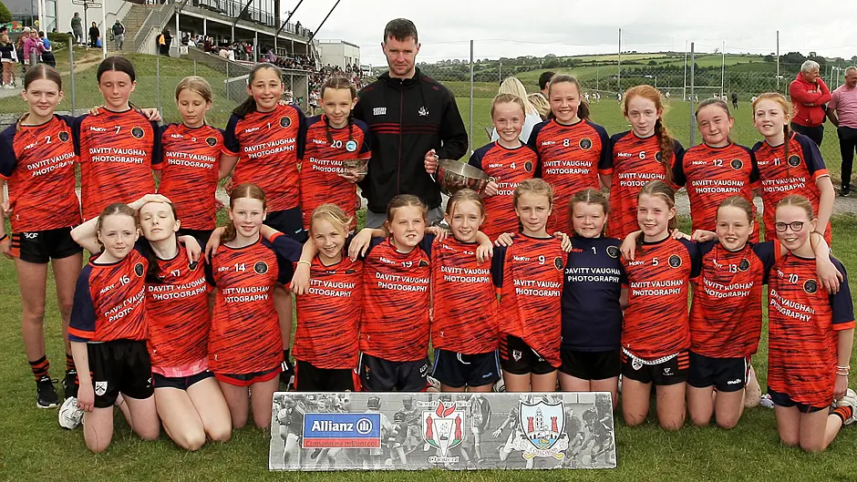 Roinn 2 Girls winners Kealkill NS receive the trophy from Cork footballer Maurice Shanley. (Photo: Paddy Feen)