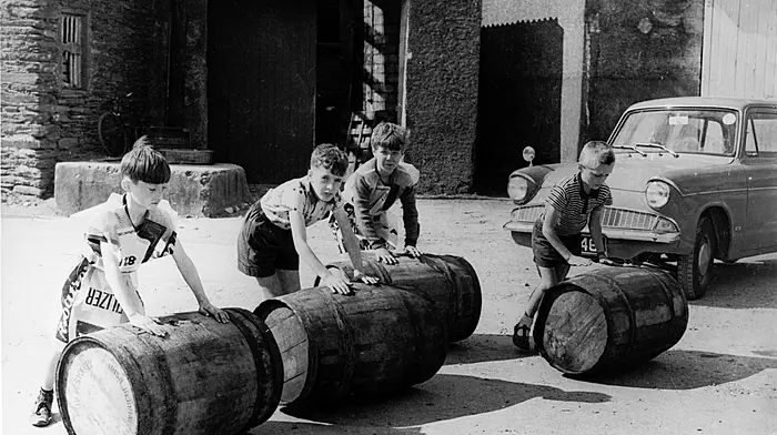 Boys rolling barrels onto the old wooden pier in Castletownbere for the salting of the fi sh during herring season, August 1967.