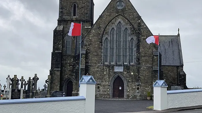 Two Cork flags outside St John the Baptist Church in Newcestown ahead of Sunday's All-Ireland hurling final.