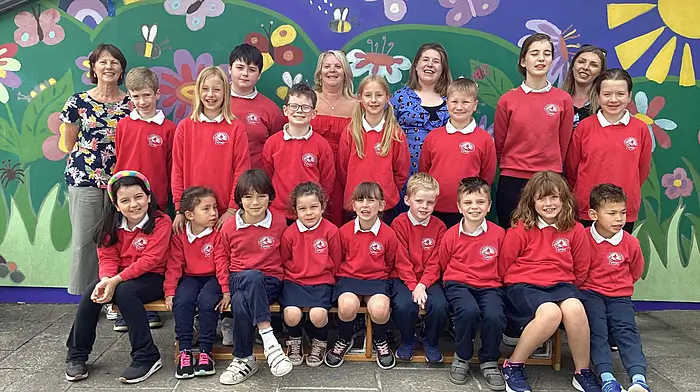 Clara McGowan with fellow staff members, Hannah Moynihan, Caroline Manning, Katie Buttimer and the pupils from Saint James' NS posing for one final photograph together before Clara retires as principal.