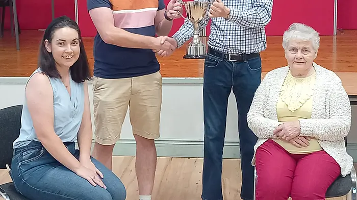 Pictured in Ballinascarthy Community Hall are the winners of the recent festival car treasure hunt Shauna and Vincent O'Flynn, being presented with the John O'Sullivan Memorial Cup by Kevin O'Sullivan and his mother Ann.