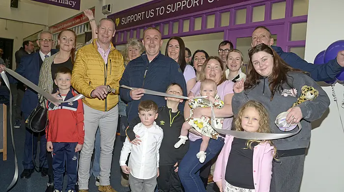Ciaran Casey cutting the tape at the recent opening of the Support Us to Support Others second hand shop in the Bandon Shopping Centre. He was helped by Adrian Linehan, with a lot of other supporters. (Photo: Denis Boyle)