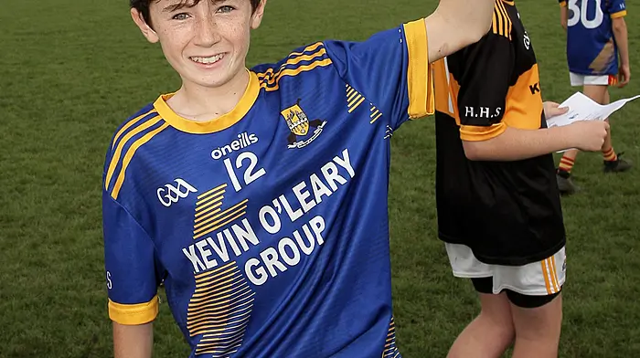 Hamilton High School captain Jack O'Donoghue raises the Raymond Lyons Perpetual Memorial Cup. (Photo: Paddy Feen)