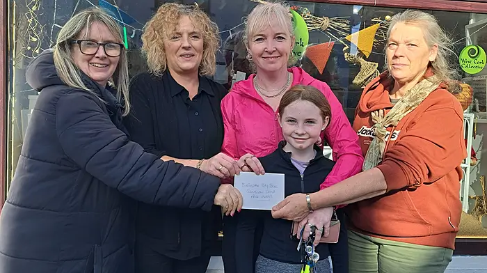 Aishling Hayes (chairman, Ballinspittle Tidy Towns) presenting the winner of the best scarecrow design with a voucher from West Cork Collective to Ena Horgan and Erin Keogh (joint winners), and with Rebecca Powell (West Cork Collective) and Addie Hayes (joint winner) in front.