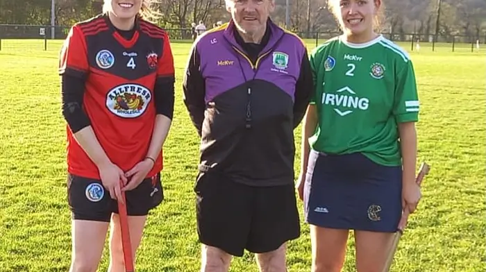 Kate O'Donovan (captain, Ballinascarthy),  Leonard Cooke (referee), and Ella Lewis (captain, Aghada) just before the start of the Lily Grant camogie match at the Henry Ford Páirc in Ballinascarthy.
