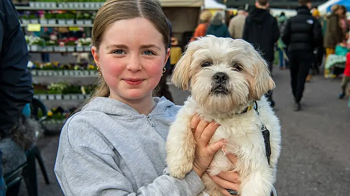 Skibbereen, West Cork, Ireland. 14th Mar, 2026. The sun shone in Skibbereen today, which brought out hundreds of people to the weekly farmers market. Enjoying the warm weather was Sarah Meehan from Dunmanway with her dog 'Daisy'. Picture: Andy Gibson.