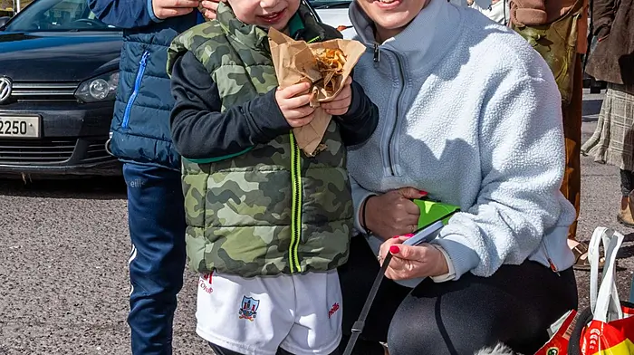 Skibbereen, West Cork, Ireland. 14th Mar, 2026. The sun shone in Skibbereen today, which brought out hundreds of people to the weekly farmers market. Enjoying the warm weather were Cayden; Jordan & Sinéad O'Donovan from Skibbereen with their dog 'Buddy'. Picture: Andy Gibson.