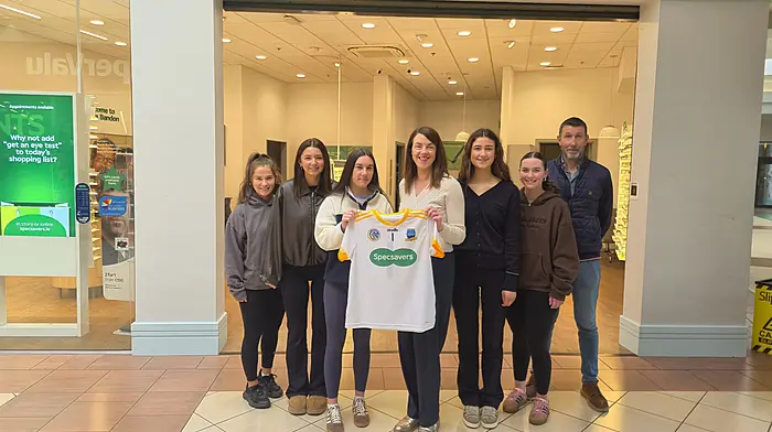Marie Burke (director, Specsavers Bandon) presenting a set of jerseys to Aisling O’Connor (captain, Bandon junior camogie team). Also included are junior players Jenny Fleming, Evelyn McCarthy, Maeve McCarthy and Breffini Kelly, along with Kevin McCarthy, coach with the minor and junior teams.