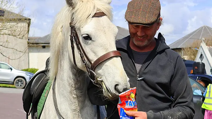 James O’Brien sharing a bag of Taytos with a friendly horse after the Schull cheval ride last Sunday.  Photo courtesy of Aughadown Community Photos.